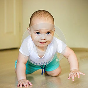 Sweet chubby baby learns to crawl on the floor