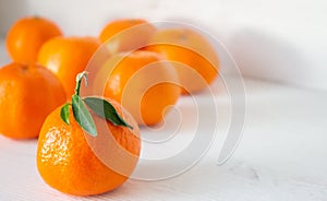 Sweet citrus fruits. Ripe mandarins clementine on white wooden background. One against all concept. Stay different concept.
