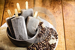 Sweet coffee ice cream, in handmade clay bowl, with coffee beans around. Cappucino Popsicles