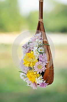 Sweet color flowers in wooden basket hanging in garden