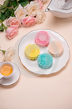 Sweet color of snow skin mooncake. Traditional mid autumn festival foods with tea on table setting.