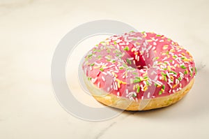 Sweet and colourful pink doughnut/Sweet and colourful pink doughnut on a marble background. Selective focus and copyspace