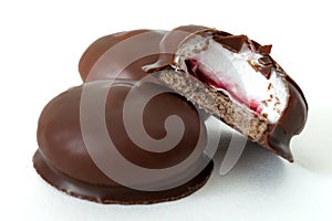 Sweet confectionery and marshmallow sweet delights concept with marshmallows coated in milk chocolate isolated on white background