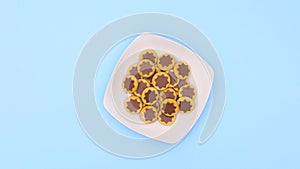 Sweet cookies appear in white plate and spin in circle. Stop motion