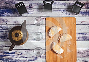 Sweet cookies on a tray with clay tea and glass tea mugs photo