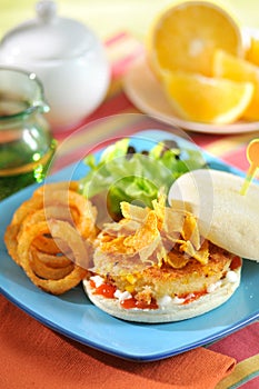 Sweet corn burger with onion and vegetables on blue plate