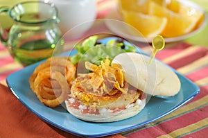 Sweet corn burger with onion and vegetables on blue plate