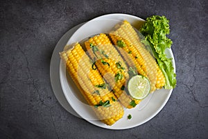 Sweet corn food with salad vegetable lime coriander and lettuce, sweet corn cooked on white plate, ripe corn cobs steamed or