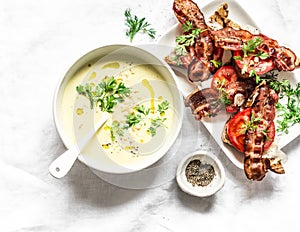 Sweet corn mashed soup with bacon tomato parmesan whole grain bread toast on light background, top view