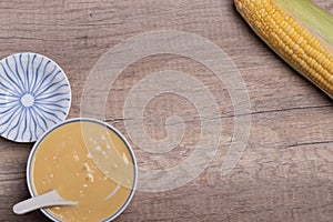 Sweet corn soup in a ceramic cup on wooden background