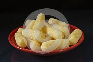 Sweet corn sticks in a red plate on the table