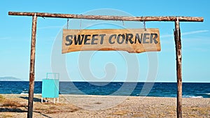 Sweet Corner sign made of wood on the beach with Aegean sea on the background, Olympiada, Greece