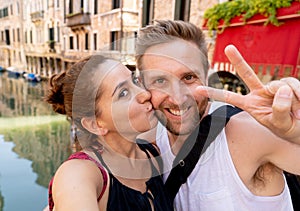 Sweet couple in love taking a selfie in Venice Italy while traveling around europe