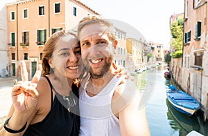 Sweet couple in love taking a selfie in Venice Italy while traveling around europe