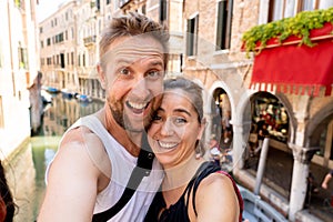 Sweet couple in love taking a selfie in Venice Italy while traveling around europe