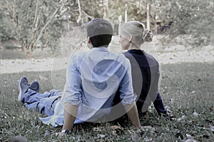 Sweet couple sitting on green grass in park  young beautiful lover spending time together and having romantic moment in summer