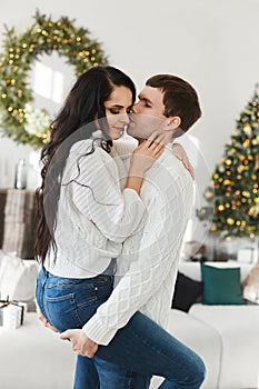 Sweet couple of young lovers spend Christmas morning at home