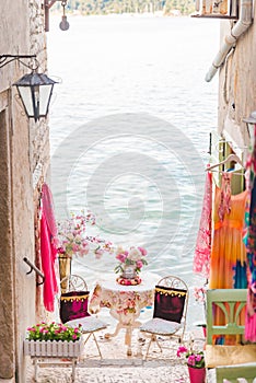 sweet cozy place table at the edge if the beach between building