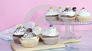Sweet cup cakes served on the table for party with white cream and crumbs