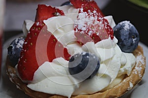 sweet cupcake from the soft fragile Linecké dought with strawberries and cream and blueberry