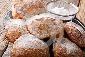 Sweet deep-fried Bunuelos sprinkled with powdered sugar close-up. horizontal