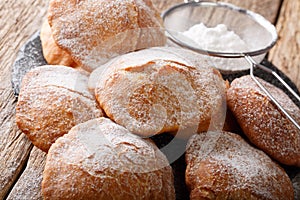 Sweet deep-fried Bunuelos sprinkled with powdered sugar close-up. horizontal photo