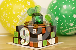 Sweet, delicious bright birthday cake for 9 years, backlit in a cube of sweet green ice