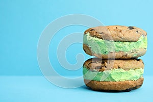 Sweet delicious ice cream cookie sandwiches on color background