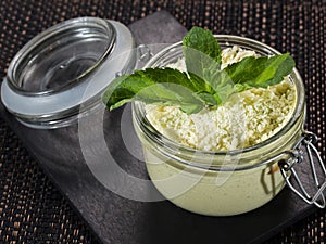 Sweet dessert tiramisu with green tea powder matcha, served in a glass jar