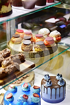 Sweet desserts and cakes in a vitrine of a cafe photo