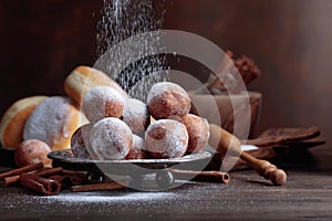 Sweet donuts with cinnamon sticks powdered with sugar.