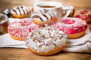 Sweet donuts, donut and cup of coffee on table