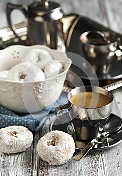 Sweet donuts with icing sugar and cup of coffee