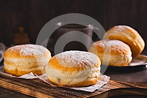 Sweet donuts with powdered sugar filled with boiled condensed milk on a plate