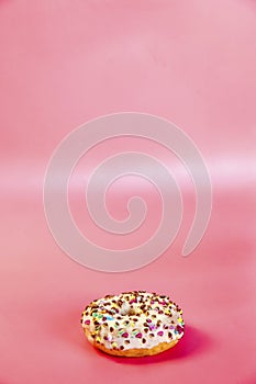 Sweet donuts stacked in a stack on a pink background. Copy space, various glaze and sprinkels chocolate chip, snack fast