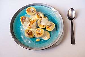 Sweet dumplings stuffed with apple, marzipane sauce on blue plate