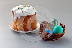 Easter cake and colorful Easter eggs in wicker basket