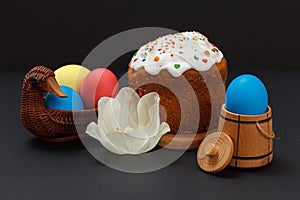 Easter cake and colorful Easter eggs in wicker basket