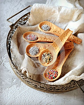 Sweet edible spoons on an iron tray on a gray background