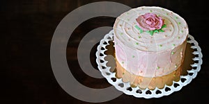 SWEET  FLORAL BUTTERCREAM BIRTHDAY  CAKE AGAINST DAR WOODEN BACKGROUND