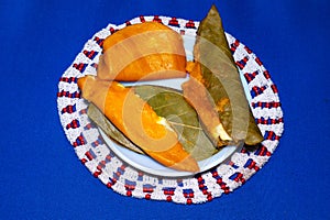 Sweet food made from a mixture of rice powder and juice of palm fruits and milk sweet  on plate on blue background