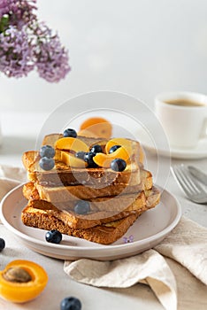 Sweet french toast with berries and syrup served on plate. Copy space for text. Healthy breakfast: toasts with blueberry and