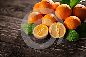 Sweet fresh oranges and half of orange on the wooden