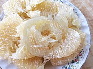 Sweet fresh pomelo peeled in a plate photo