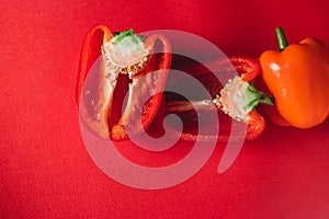 SWEET, fresh RED PEPPER ON A RED BACKGROUND, cut in half. photo for the menu, proper nutrition. fresh vegetables