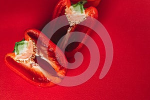 SWEET, fresh RED PEPPER ON A RED BACKGROUND, cut in half. photo for the menu, proper nutrition. fresh vegetables