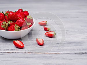 Sweet fresh strawberries in bowl on a wooden table. Food concept.