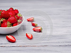 Sweet fresh strawberries in bowl on a wooden table. Food concept.