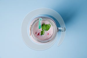Sweet fresh strawberries jogurt in mason jar on a blue background. Food concept.
