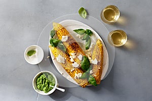 Sweet fried corn with basil sauce, feta cheese, wine top view